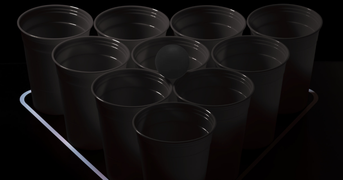 10 schwarze Bierpong Becher in einer Pyramide aufgestellt mit schwarzem Tischtennisball darauf liegend