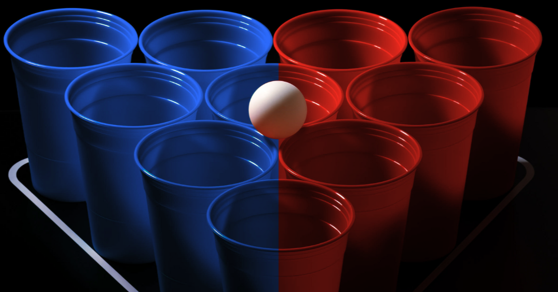 10 blaue und rote Bierpong Becher in einer Pyramide aufgestellt mit weißem Tischtennisball darauf liegend