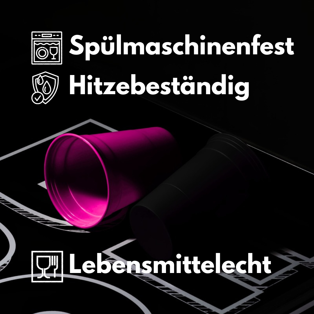 Zwei Beerpong Becher in pink und schwarz liegen auf einem Bierpongtisch. Schriftzug: Spülmaschinenfest, Hitzebeständig, Nachhaltig und Lebensmittelecht